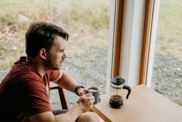 Pondering man with black coffee resting in countryside house