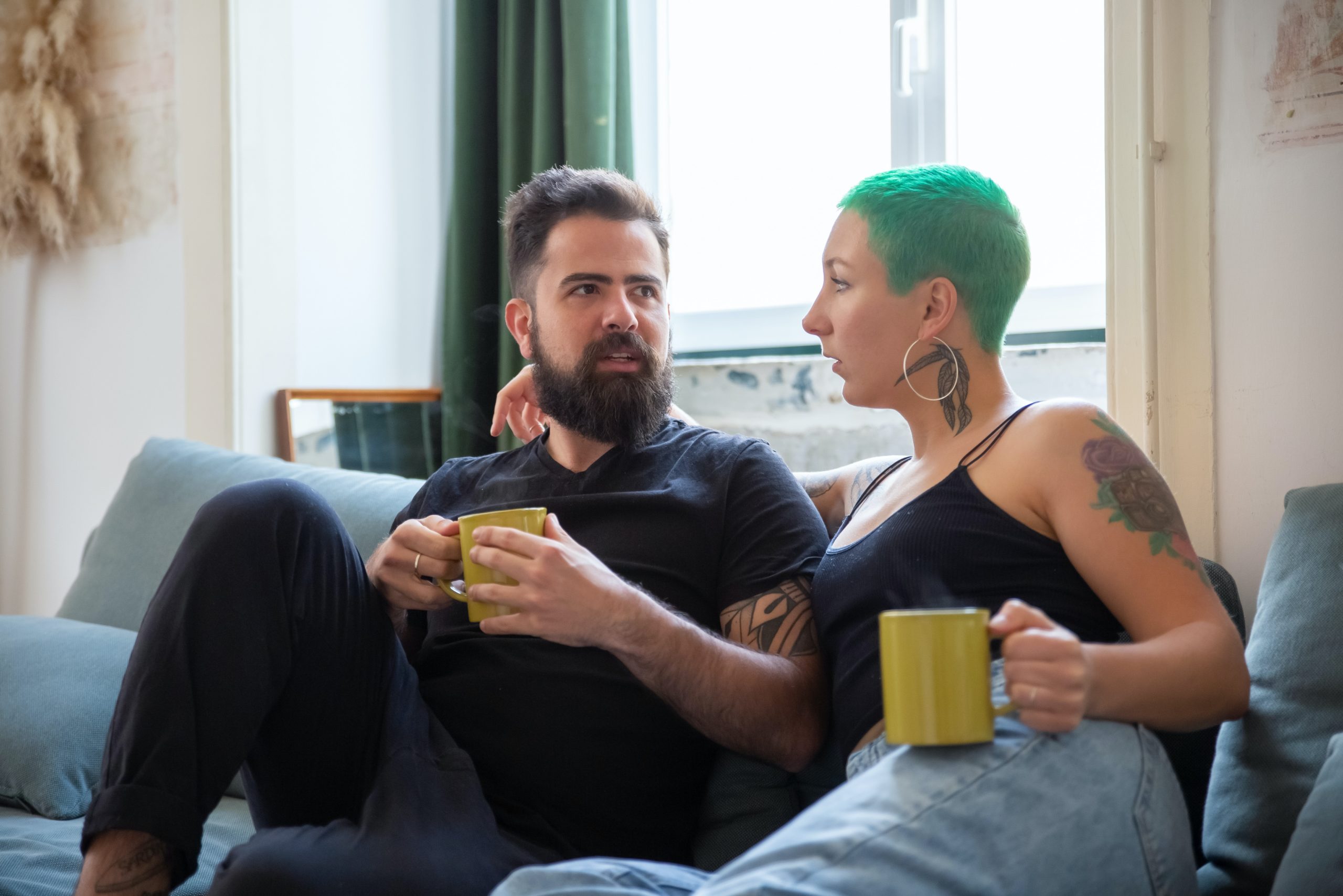 Man in Black Crew Neck Shirt Holding Yellow Ceramic Mug Beside a Woman