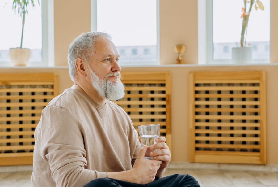 Man in Brown Sweater Sitting on Floor