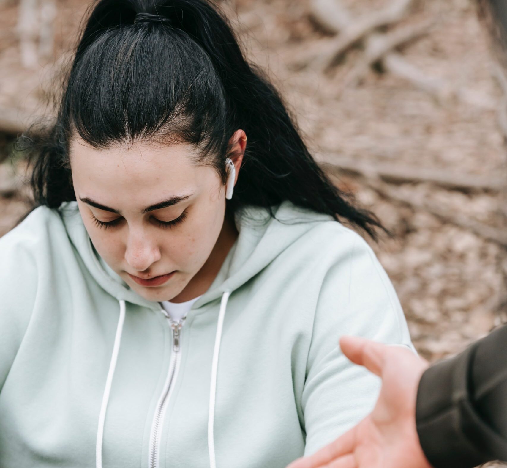 Tired female sitting on ground and looking down
