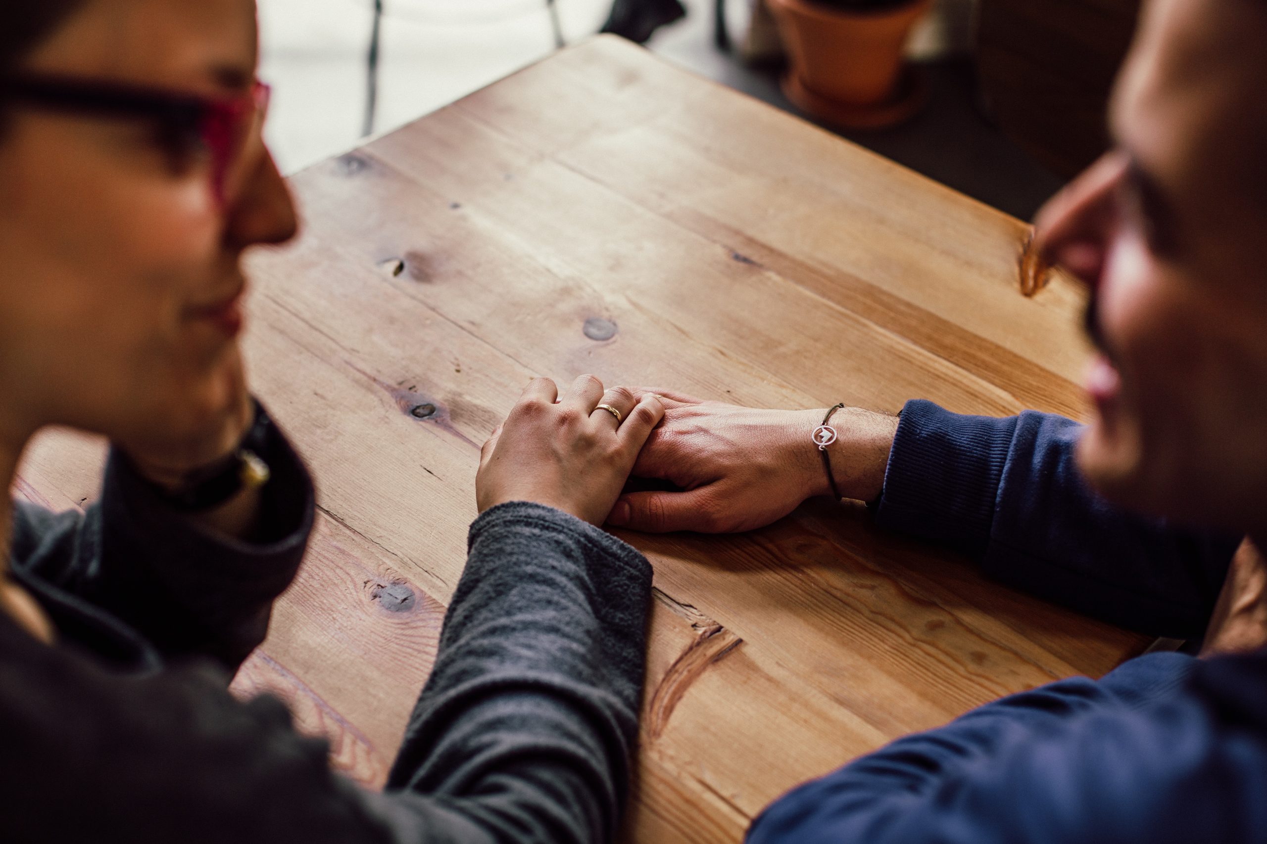 two people talking holding hands